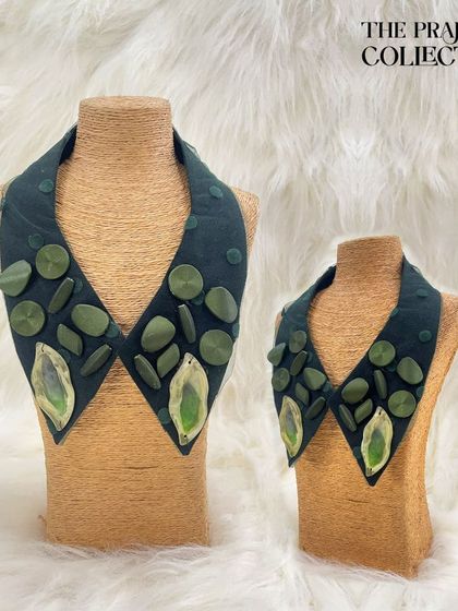 This detachable collar in a deep olive green features an arrangement of matching green stones and two striking marbled accent gems. It offers an earthy yet sophisticated way to accessorize.