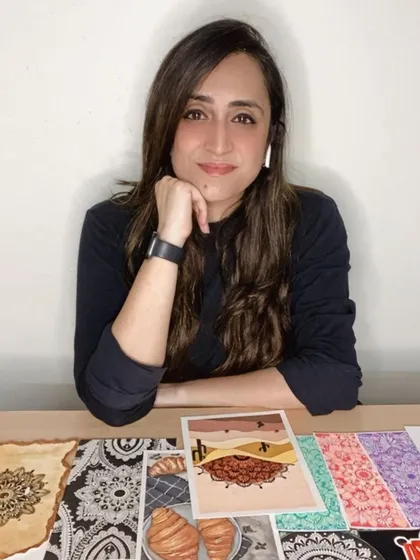 A shot of me with a collection of my recent artworks. Each piece, whether it's a coffee-stained mandala or a colorful food illustration, holds a special place in my portfolio.