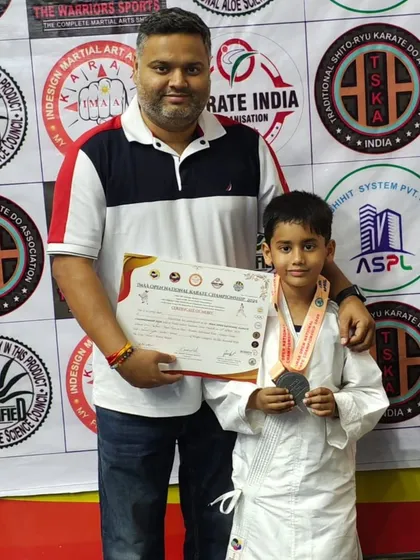 A junior athlete with his father and his silver medal. Every win, big or small, is a step forward on the journey.