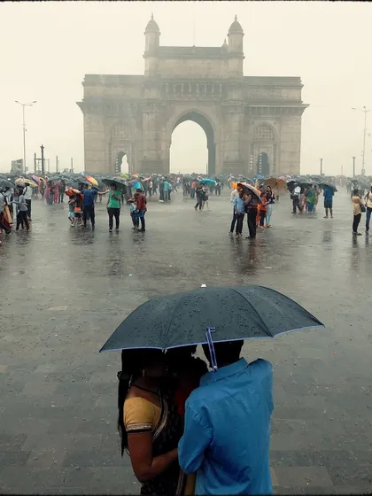 A couple shares an intimate moment under an umbrella, with the Gateway of India softly blurred in the rainy background. This photo tells a classic story of love in the city, made more romantic by the monsoon atmosphere.