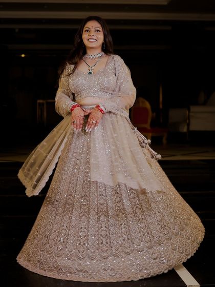 A full-length shot of the bride twirling in her intricately detailed lehenga for her engagement ceremony.
