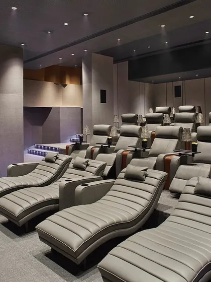 A view of the private theater designed for Rustomjee Elements. The space is optimized for acoustics with undulated wall panels and features luxurious, comfortable recliners to provide an exclusive, cozy viewing experience for residents.