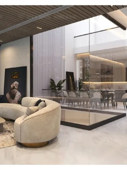 A stunning double-height living space in Mansarovar Garden, where a glass partition separates the dining area, creating a sense of openness and grandeur.