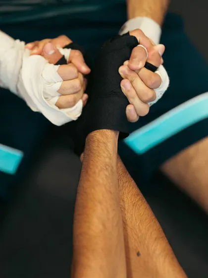 A close-up of two fighters stretching together, a sign of the supportive community at our gym.