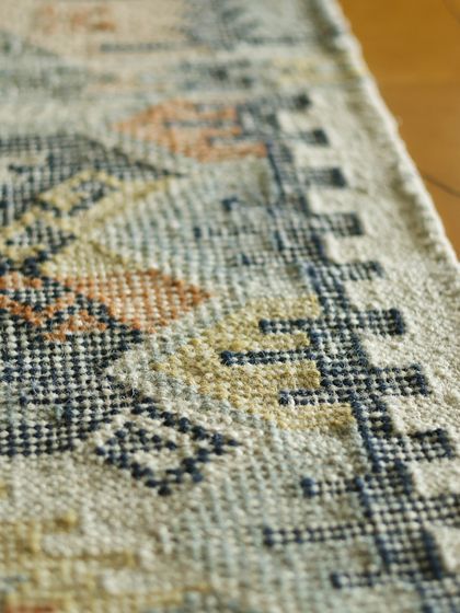 This macro shot shows the individual threads and the geometric motifs of a dhurrie. It is a testament to the timeless design and durable construction that makes these rugs a beloved part of our collection.