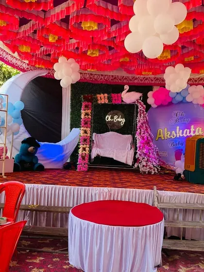 Another angle of the baby shower stage, showing the arrangement of props and the cake table.