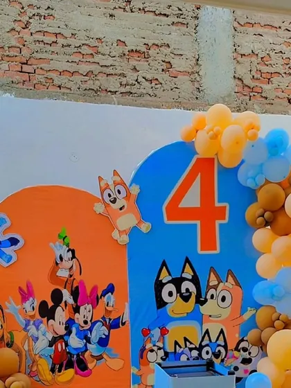 This party features characters from the show 'Bluey'. I created a custom backdrop with a large number '4' and character cutouts, surrounded by a blue and orange balloon garland.