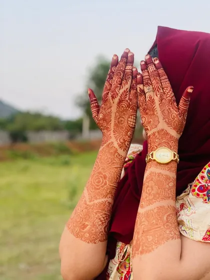 A shy pose that perfectly shows off the beautiful stain on both arms. The design's delicate lines and patterns are clearly visible thanks to the deep, even color.