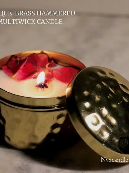 A lit antique brass hammered candle with a lid. The warm glow and the scent of the candle make it a perfect gift to share during the festive season.