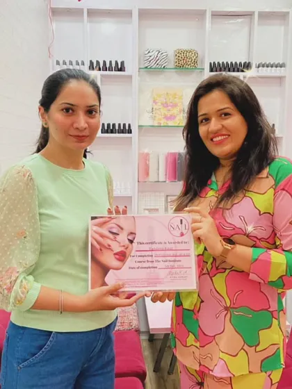 Presenting a certificate of completion to a dedicated student who has mastered the skills taught in our professional nail course.