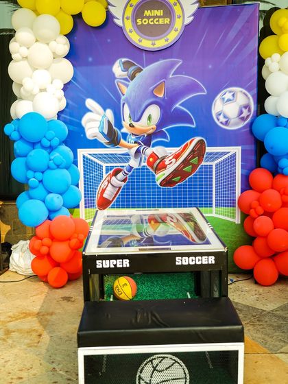 A mini "Super Soccer" table game with a Sonic the Hedgehog backdrop, perfect for some friendly competition.