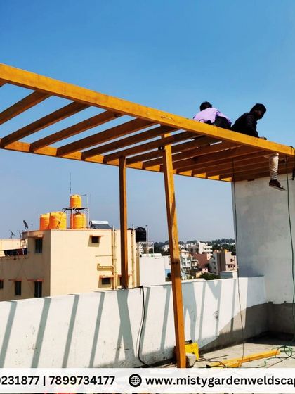 A side view of the pergola installation, showing how the structure extends from the existing building to create a new, covered outdoor area.