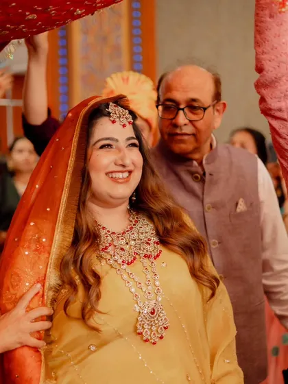 Capturing the joy of this bride's wedding ceremony. Her makeup is traditional and radiant, with warm tones and defined eyes, paired with soft waves for a look that is both classic and effortlessly beautiful.