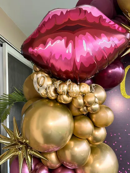 Another detail shot of the "Celebrating Me" party. The large, pouty lip foil balloon paired with a cascade of chrome gold balloons creates a bold and luxurious statement.