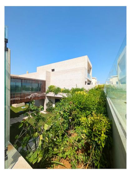 The 'Wahatan' villa in Dubai, where green roofs and planted terraces spill over the brick walls, creating a lush oasis.