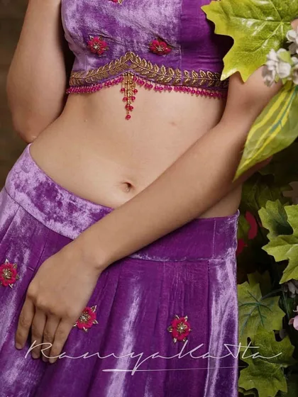 A mid-shot of the lavender velvet lehenga, highlighting the detailed craftsmanship of the blouse and the rich texture of the fabric.