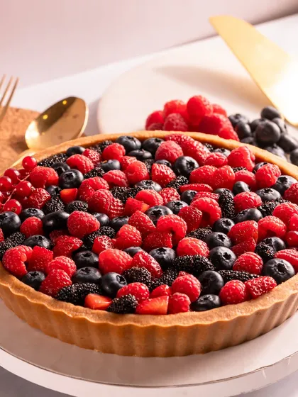 My signature Berry Tart is a true crowd-pleaser. A golden, buttery crust holds a rich chocolate pudding, all hidden under a vibrant medley of juicy, fresh seasonal berries. It’s a dessert that lives rent-free in your head.