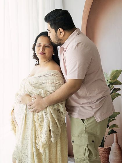 A gentle embrace from behind, with the father-to-be kissing his partner's head. This pose is both romantic and protective.