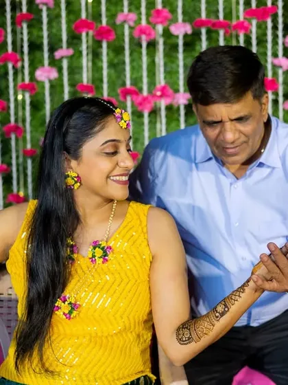A touching moment between the bride and her father as he admires her mehendi design.