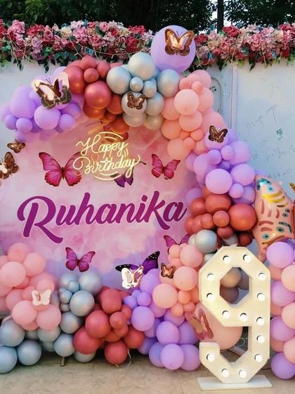 A clear, bright shot of the outdoor butterfly setup for a 9th birthday. The colors pop against the floral background, making it perfect for daytime parties.