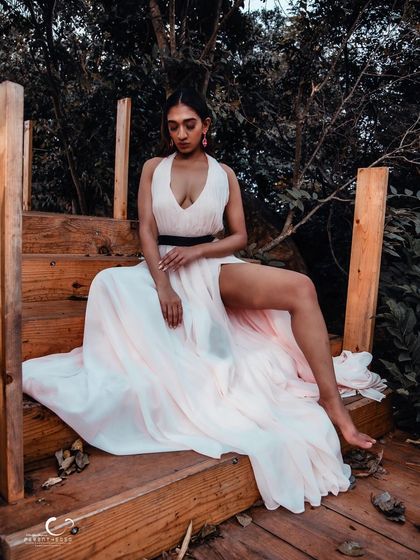 An elegant and relaxed seated pose on a wooden staircase. The flowing white gown creates a beautiful, romantic silhouette.