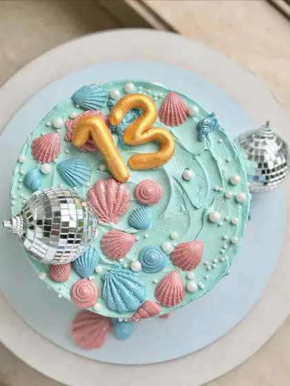 Shells, pearls, and disco balls. This 13th birthday cake is giving coastal luxury meets party vibes. I used fondant seashells, edible pearls, and mini disco balls to create a fun, shimmering underwater world. 🪩🌊