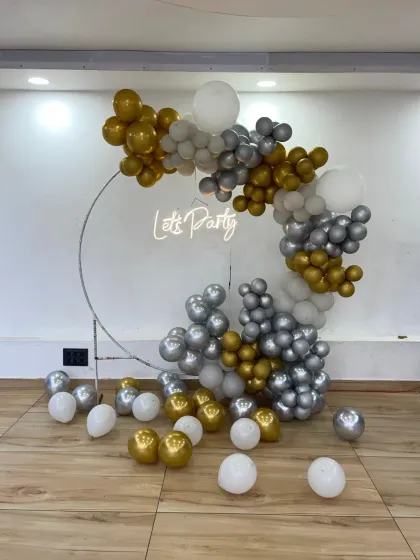 Another angle of the silver and gold ring backdrop, showing some loose balloons scattered on the floor to extend the decorative effect.
