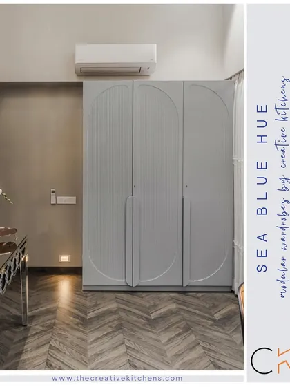 A full view of the sea blue wardrobe, showing its clean silhouette and how the unique fluted and arched pattern becomes a central design feature in the room.