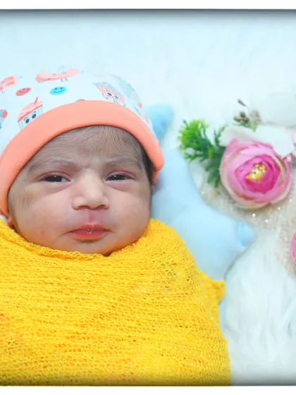 A sweet portrait of an alert newborn in a yellow wrap, looking right at the camera. I capture both sleepy and awake moments during a session.