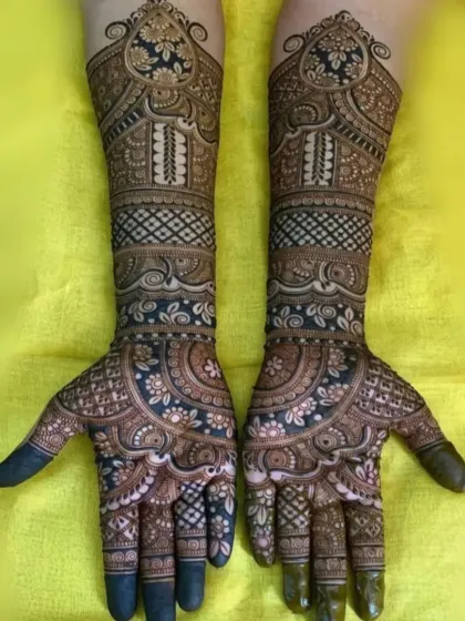 A rich, dark-stained bridal mehndi with intricate floral and paisley patterns. I ensure the henna paste is of the highest quality for a deep, long-lasting color.