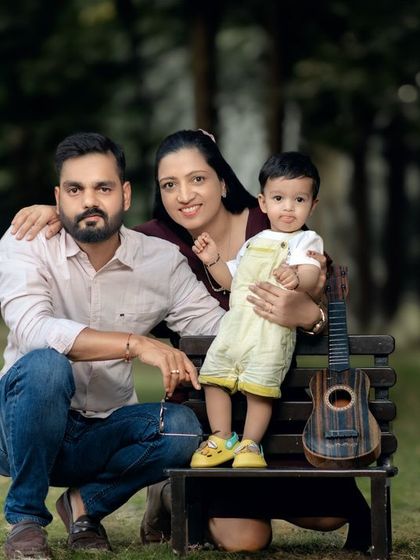 A classic family portrait taken outdoors on a park bench. We incorporate props like this small guitar to add a personal and playful touch.