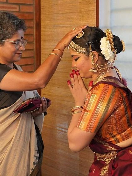 A behind-the-scenes moment from 'Rasayatra', where the dancer receives blessings from her guru before the show. This captures the deep respect and tradition inherent in classical dance.