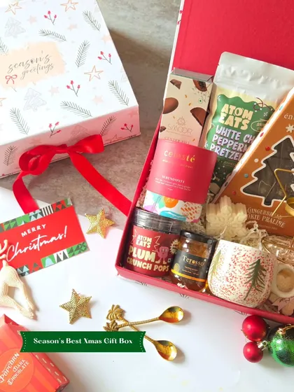 The Season's Best Xmas Gift Box is beautifully presented with a "Merry Christmas" tag. It contains plum crunch pops, white chocolate pretzels, and other gourmet goodies.
