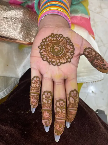 A simple and pretty design for siders or guests. This look features a central mandala with matching floral details on each finger, leaving much of the hand open.