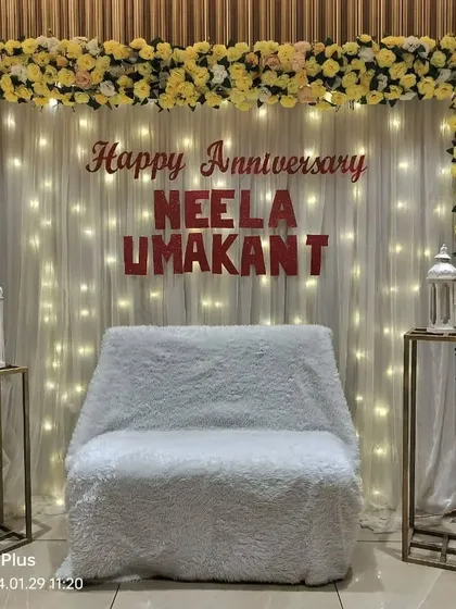 A full view of the 50th anniversary stage, featuring a floral frame, personalized names, and elegant white lanterns on stands.