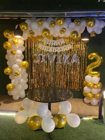 A full view of the white and gold second birthday setup.