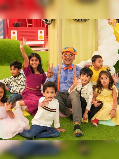 Blippi posing with a group of excited kids. Having a beloved character at a party creates unforgettable moments and fantastic photo opportunities.
