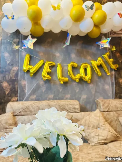 A close-up of the welcome banner and balloon garland. The little butterfly and star details add a touch of whimsy to the setup.