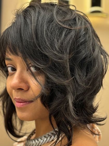 A bold and beautiful short haircut with lots of texture and movement. The choppy layers and side-swept bangs create an edgy, modern look.