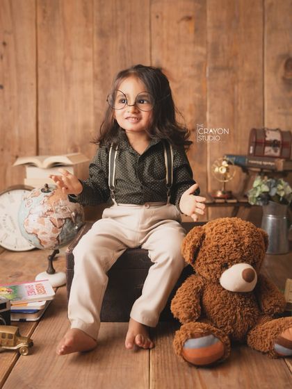 Sitting with his teddy bear friend, this little scholar is ready for a day of learning and adventure.
