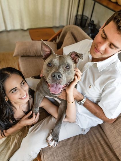 A beautiful portrait of an engaged couple holding their beloved pitbull, Millie. Her happy, smiling face shows she's just as excited about the celebration as they are.