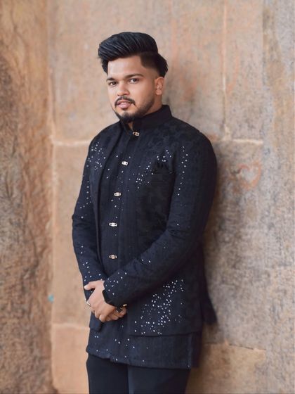 A confident portrait of a model in the black layered Indo-Western outfit. The subtle sparkle of the embellishments adds a touch of festivity.