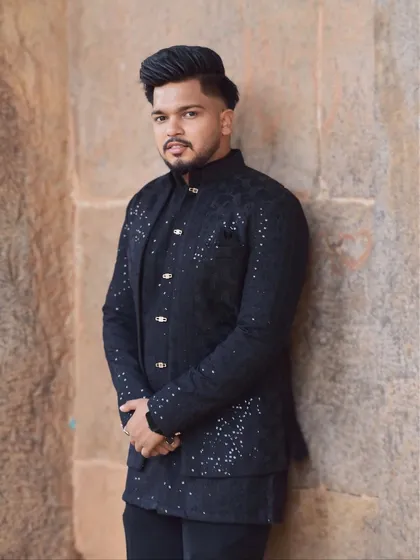 A confident portrait of a model in the black layered Indo-Western outfit. The subtle sparkle of the embellishments adds a touch of festivity.