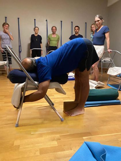 A supported forward bend with a chair.