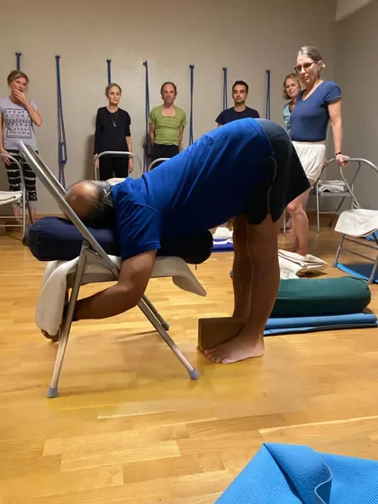 A supported forward bend with a chair.