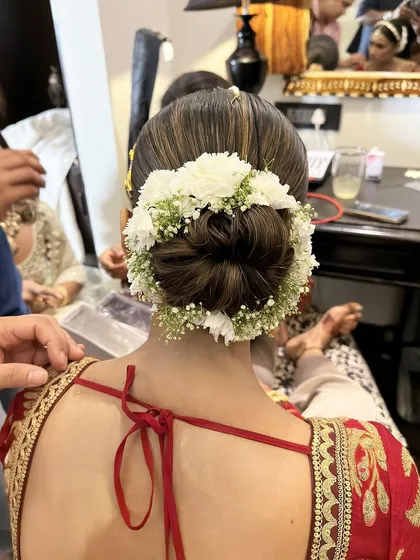An identical shot showing the timeless elegance of a simple, well-executed floral bun for a wedding day.