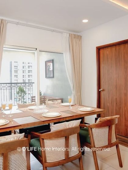 A bright and airy dining space designed for family meals. The use of natural wood tones and simple, elegant chairs creates a welcoming atmosphere that connects seamlessly to the outdoor balcony.
