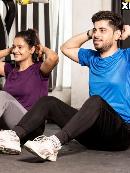 A couple doing sit-ups together. Training with a partner can make core workouts more fun and motivating.
