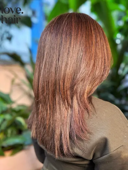 The back view showcases the seamless blend of this mahogany glaze. The layered cut adds movement, allowing the different tones in the balayage to stand out.
