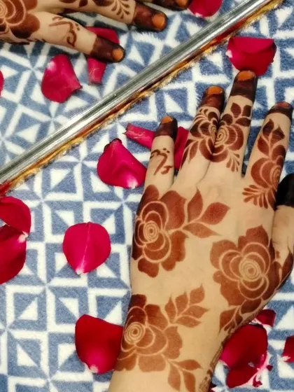 The reflection in the mirror shows the beauty of the henna stain. This design features a lovely floral pattern with a rich, dark color.